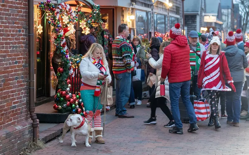 Strollers in festive sweaters and Stroll hats outside a decorated shop