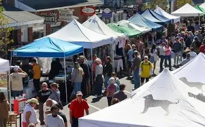 Vendor tents and shoppers at a downtown street market
